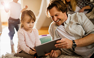 Father and young daughter on tablet